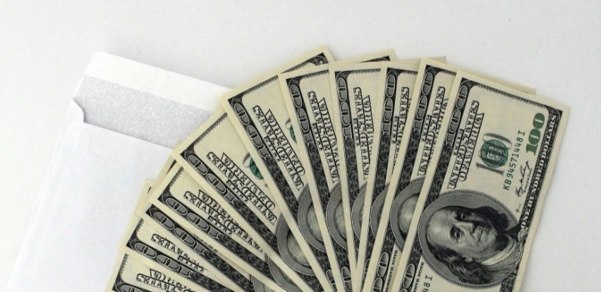A white envelope and dollar bills on a table