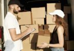 A man and a woman putting packages in a van