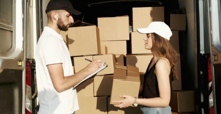 A man and a woman putting packages in a van
