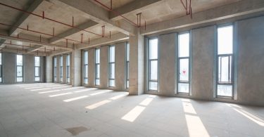 A large commercial space with concrete walls and a concrete floor. The space in undecorated.